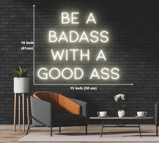 A neon sign with the words 'be a badass with a good ass' glowing in vibrant colors.