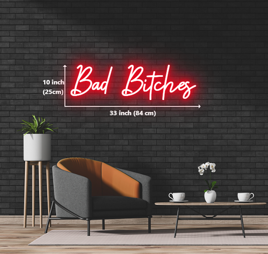 A neon sign displaying the phrase "bad bitches" in vibrant colors, illuminating a bold and empowering message.